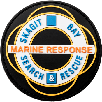 Circular PVC patch for Skagit Bay Marine Response Search and Rescue featuring blue, orange, and white raised lettering on a black background.