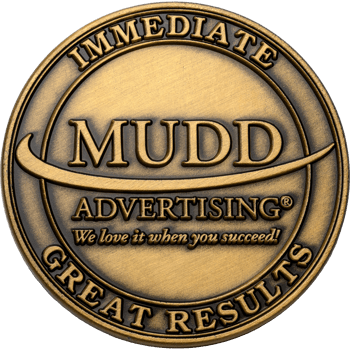 Antique brass challenge coin featuring the Mudd Advertising logo with the text Immediate Great Results.