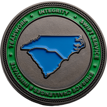 Round challenge coin featuring blue enameled outlines of North and South Carolina on a textured silver background with a green border.