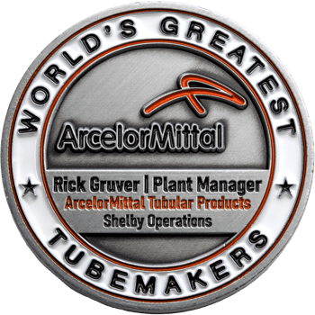 Antiqued silver challenge coin for ArcelorMittal Shelby Operations featuring the World's Greatest Tubemakers slogan and Rick Gruver Plant Manager name.
