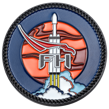 Circular soft enamel coin featuring the letters FH over a rocket ship, red bird silhouette, and orange sun with a black rope border.