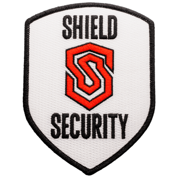 Shield Security uniform patch featuring a red and black stylized S logo on a white background with a black border.