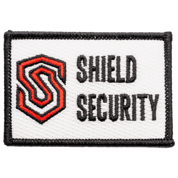Rectangular embroidered patch with a red and black stylized 'S' logo and Shield Security text on a white background with a black border.