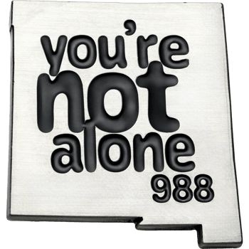 Silver lapel pin shaped like New Mexico featuring the text You're Not Alone and the number 988 in black recessed lettering.