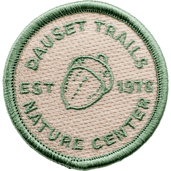 Circular embroidered patch for Dauset Trails Nature Center featuring a center acorn icon and green border.