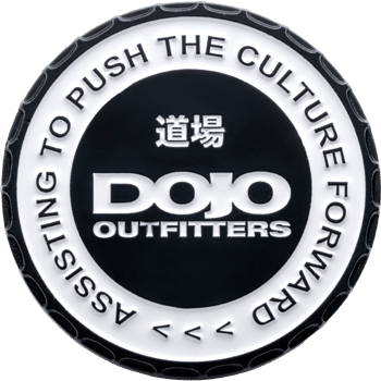Black and white PVC challenge coin for Dojo Outfitters with Japanese characters and text reading Assisting to Push the Culture Forward.