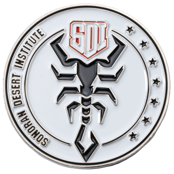 Sonoran Desert Institute challenge coin featuring a black scorpion emblem, SDI shield logo, and stars on a white enamel background.