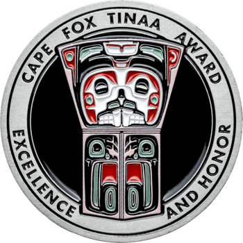 Silver challenge coin with Cape Fox Tinaa Award text, Tlingit style totem art in red, white, and green enamel on a black background.