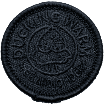 Circular black embroidered patch with the text 'Ducking Warm' and 'Nice and Cider' featuring a central cup icon.