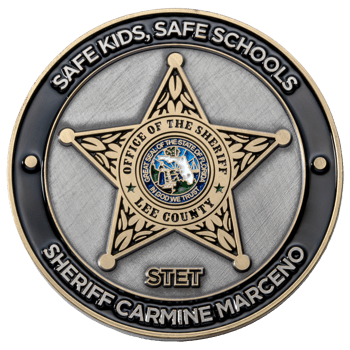 Circular challenge coin featuring a Lee County Sheriff star, the Florida state seal, and the text Safe Kids Safe Schools.